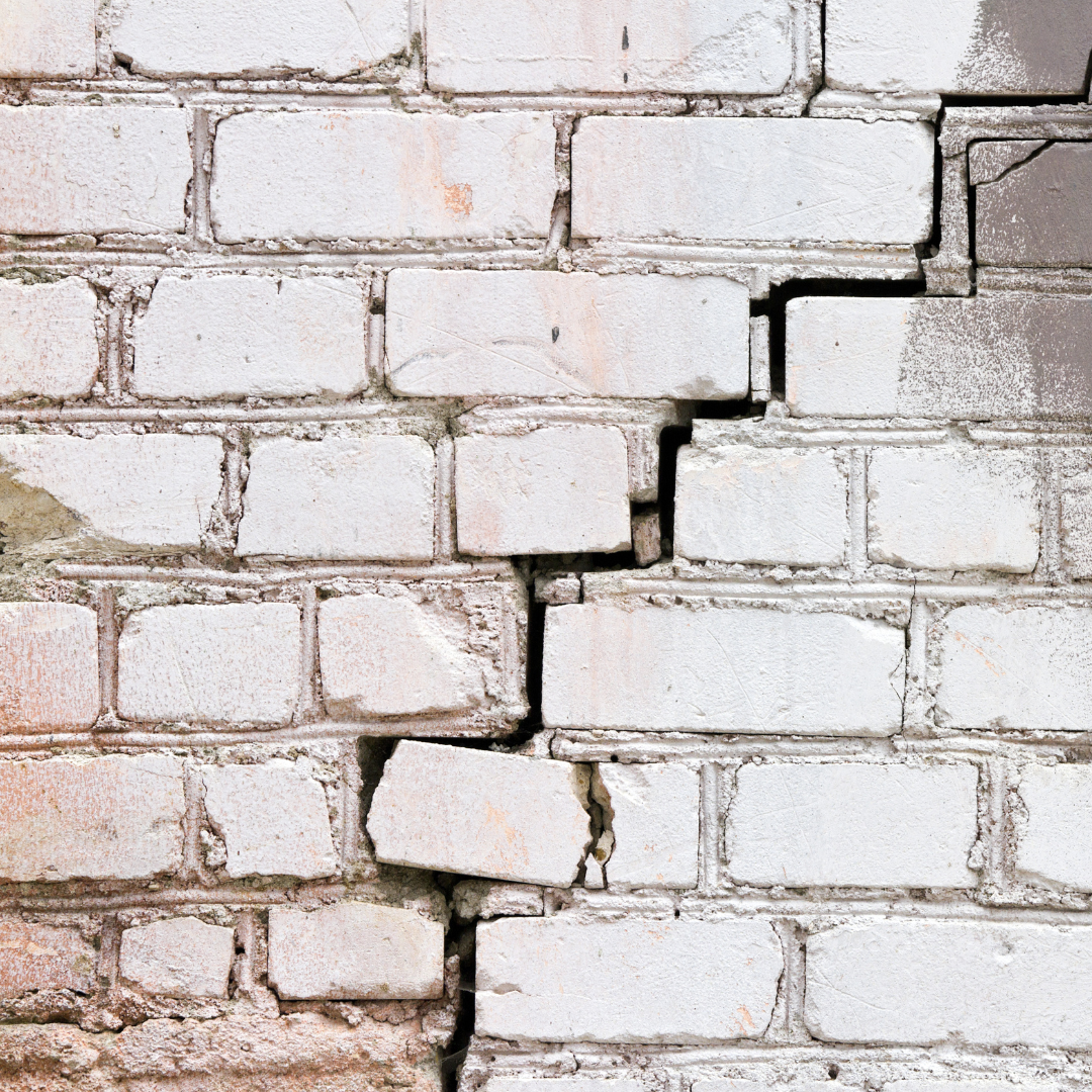 A large stair stepped crack in a brick wall.
